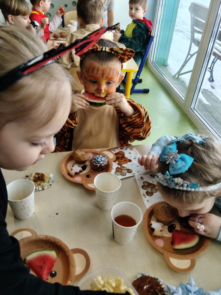 Misie biorą udział w poczęstunku podczas balu karnawałowego.