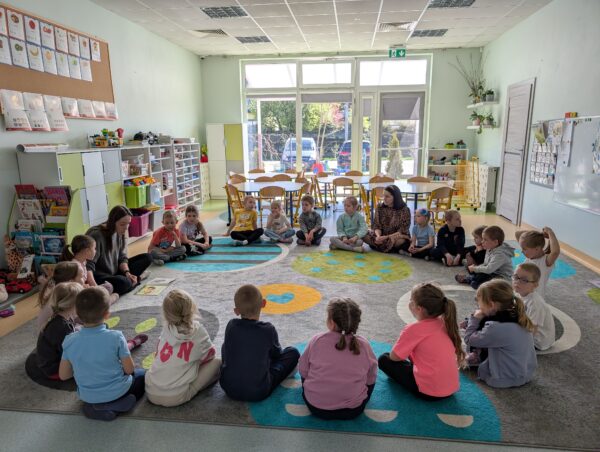 Dzieci z zainteresowaniem słuchają czytanej książki